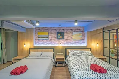 two beds in a bedroom with red pillows on them at Private apartment in Huaikwang in Bangkok