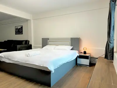 a bedroom with a bed and a living room at Berlin Haus in Nonthaburi
