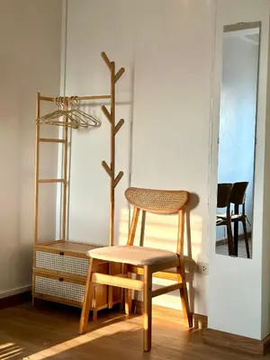 a wooden chair and a stool in a room at Sukkasame Apartment At Ngamwongwan in Ban Bang Khen (1)