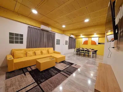 a living room with a yellow couch and a table at The Yellow House Poolvilla in Sathani Ban Hua Mak