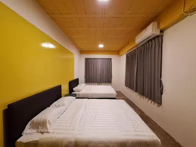 two beds in a room with yellow walls at The Yellow House Poolvilla in Sathani Ban Hua Mak