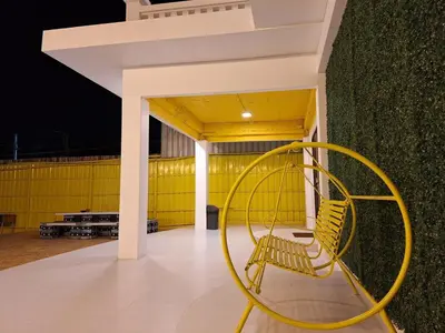 a yellow bench sitting in front of a building at The Yellow House Poolvilla in Sathani Ban Hua Mak