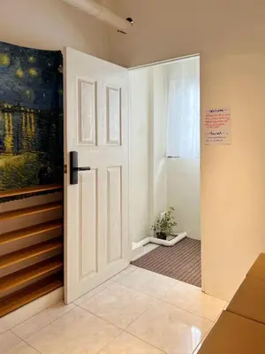 a white door in a room with a painting at smoking buddy house in Bangkok