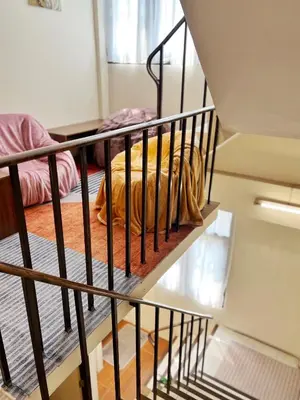 a metal staircase with a bed in a room at smoking buddy house in Bangkok