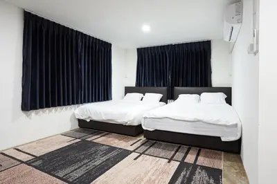 two beds in a room with white walls and black curtains at Number 8 Poolvilla Bangkok in Sathani Ban Hua Mak