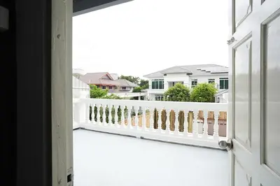 an open door to a balcony with a white railing at Number 8 Poolvilla Bangkok in Sathani Ban Hua Mak