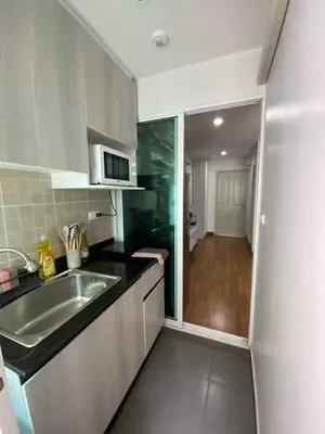 a small kitchen with a sink and a microwave at Stunning Condo - BTS On Nut - Pool, Gym, Wi-Fi in Bangkok