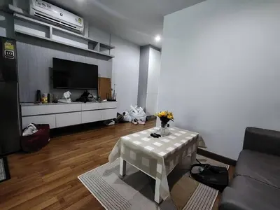 a living room with a table with flowers on it at Stunning Condo - BTS On Nut - Pool, Gym, Wi-Fi in Bangkok