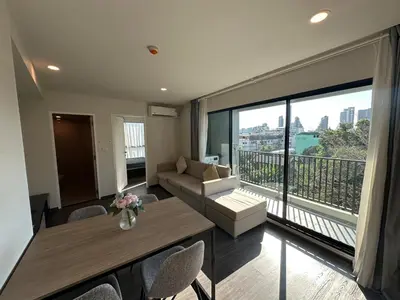 a living room with a couch and a large window at Chill Condo near Icon Siam in Bangkok