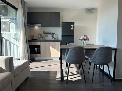 a kitchen with a table and chairs in a living room at Chill Condo near Icon Siam in Bangkok