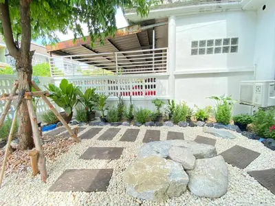 a garden with a fire pit in front of a building at Cheap house 7min next to BTS Kasetsart , 5 bedroom in Ban Yang