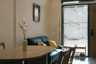 a living room with a table and a blue couch at SuXiang - Chinatown, Bangkok in Bangkok