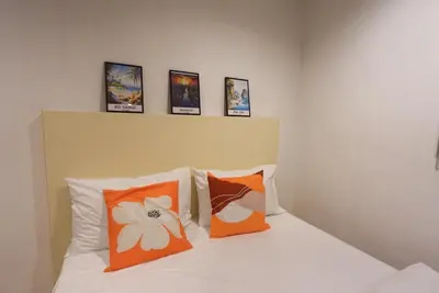 a bedroom with a bed with orange and white pillows at Sampheng House in Bangkok