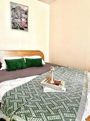 a bed with a book and a vase on it at CinCin Popular Condo in Thung Si Kan