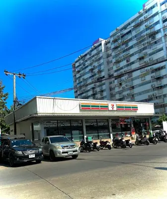 a parking lot with motorcycles parked in front of a building at CinCin Popular Condo in Thung Si Kan