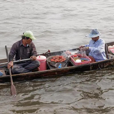 two men sitting in a boat in the water at Baan Manee BKK in Bangkok