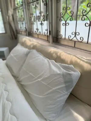 a white pillow sitting on a bed with windows at 5 beds private garden resort 452sqm Pet relax in Sathani Ban Hua Mak