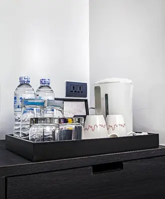 a tray with water bottles and a clock on a counter at Galleria 12 Sukhumvit Bangkok by Compass Hospitality in Bangkok