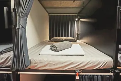 a bunk bed with a towel on top of it at Hash Capsule Hostel Silom Soi 3 in Bangkok