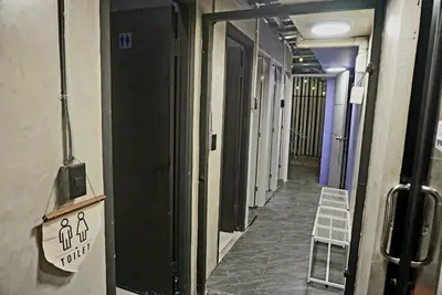a hallway of a building with a sign on the wall at Hash Capsule Hostel Silom Soi 3 in Bangkok