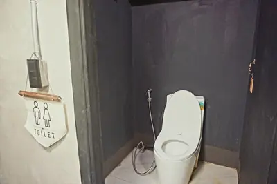 a small bathroom with a toilet in a stall at Hash Capsule Hostel Silom Soi 3 in Bangkok
