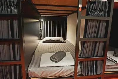 a bedroom with two bunk beds and a bed at Hash Capsule Hostel Silom Soi 3 in Bangkok