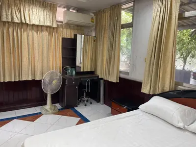 a bedroom with a bed and a desk with a fan at Home Rama 4 near BTS Thong Lor in Khlong Toei