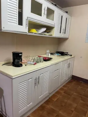 a kitchen counter with white cabinets in a room at Home Rama 4 near BTS Thong Lor in Khlong Toei