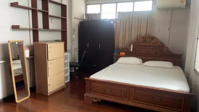 a bedroom with a bed and a dresser in it at Home Rama 4 near BTS Thong Lor in Khlong Toei