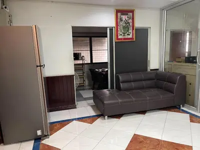 a living room with a leather couch in a room at Home Rama 4 near BTS Thong Lor in Khlong Toei