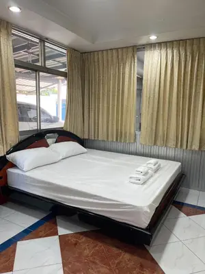 a large bed in a room with windows at Home Rama 4 near BTS Thong Lor in Khlong Toei