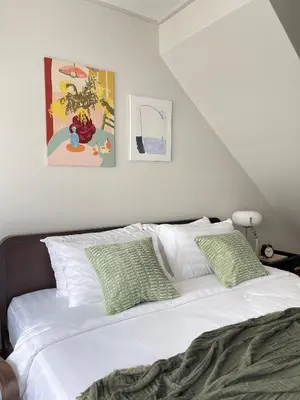 a white bed with green pillows in a bedroom at Nueng Rana 113 Unique House in Chinatown 3BR 2BA - Villa in Samphanthawong