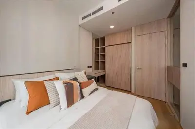 a bedroom with a large white bed and wooden cabinets at \u7d20\u5764\u9038\u6cbf\u7ebfBTS Ekkama Station in Bangkok
