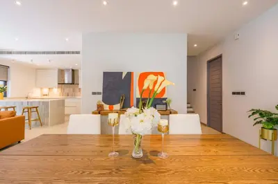 a dining room table with a vase of flowers on it at Designer 49 Pool Villa in Bangkok
