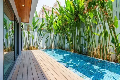 a swimming pool in a house with plants at Designer 49 Pool Villa in Bangkok