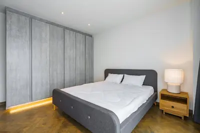 a bedroom with a large bed with a gray headboard at Designer 49 Pool Villa in Bangkok