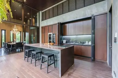 a kitchen with a large island with bar stools at Luxury Modern Pool Jacuzzi Villa 5BR Thonglor in Khlong Toei