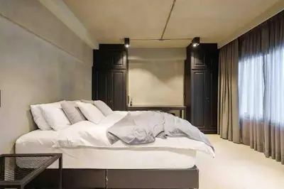 a bedroom with a large white bed with black cabinets at Luxury Modern Pool Jacuzzi Villa 5BR Thonglor in Khlong Toei
