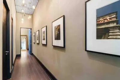 a hallway with a row of framed pictures on a wall at Luxury Modern Pool Jacuzzi Villa 5BR Thonglor in Khlong Toei