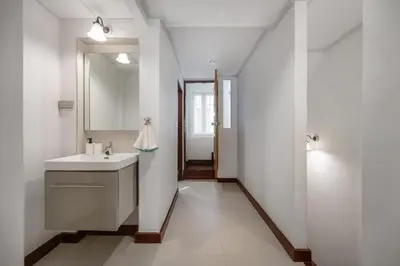 a white bathroom with a sink and a mirror at Sunfire House Chinatown in Bangkok