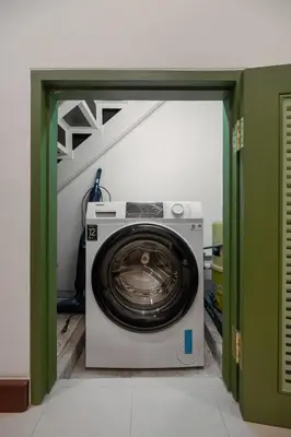 a washing machine in a room with a green door at Sunfire House Chinatown in Bangkok