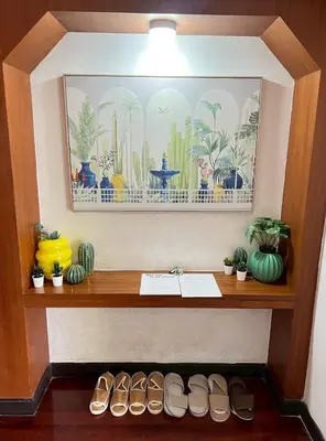 a wooden shelf with shoes and a painting on the wall at AT ASok Vintage House Near BTS Asok MRT Sukhumvit in Khlong Toei