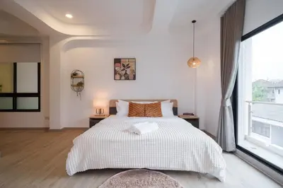 a bedroom with a bed and a large window at Ayas Retreat - Muji Ekkamai Pool Villa with 4 bedrooms in Khlong Toei