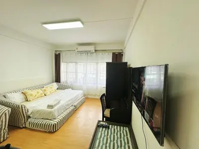 a living room with a couch and a flat screen tv at Top Location! 800m MRT Rama9 in Bangkok