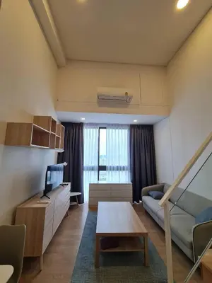 a living room with a couch and a table at Rama9 Loft Life in Bangkok
