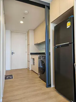 a kitchen with a black refrigerator in a room at Rama9 Loft Life in Bangkok