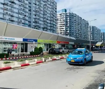 a blue car parked in a parking lot in front of a building at ห้องเช่ารายวัน เมืองทองธานี C5 By ณดา in Ban Bang Phang