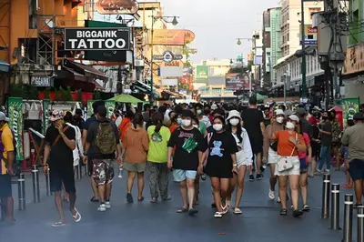 a crowd of people walking down a busy city street at GO INN Khaosan - โกอินน์ ตรอกข้าวสาร in Bangkok