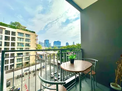 a balcony with a table and chairs and a view of a city at Bright & Spacious Apartment in Bangkok