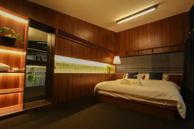 a bedroom with a bed with wood paneled walls at baansaensaep in Pratunam